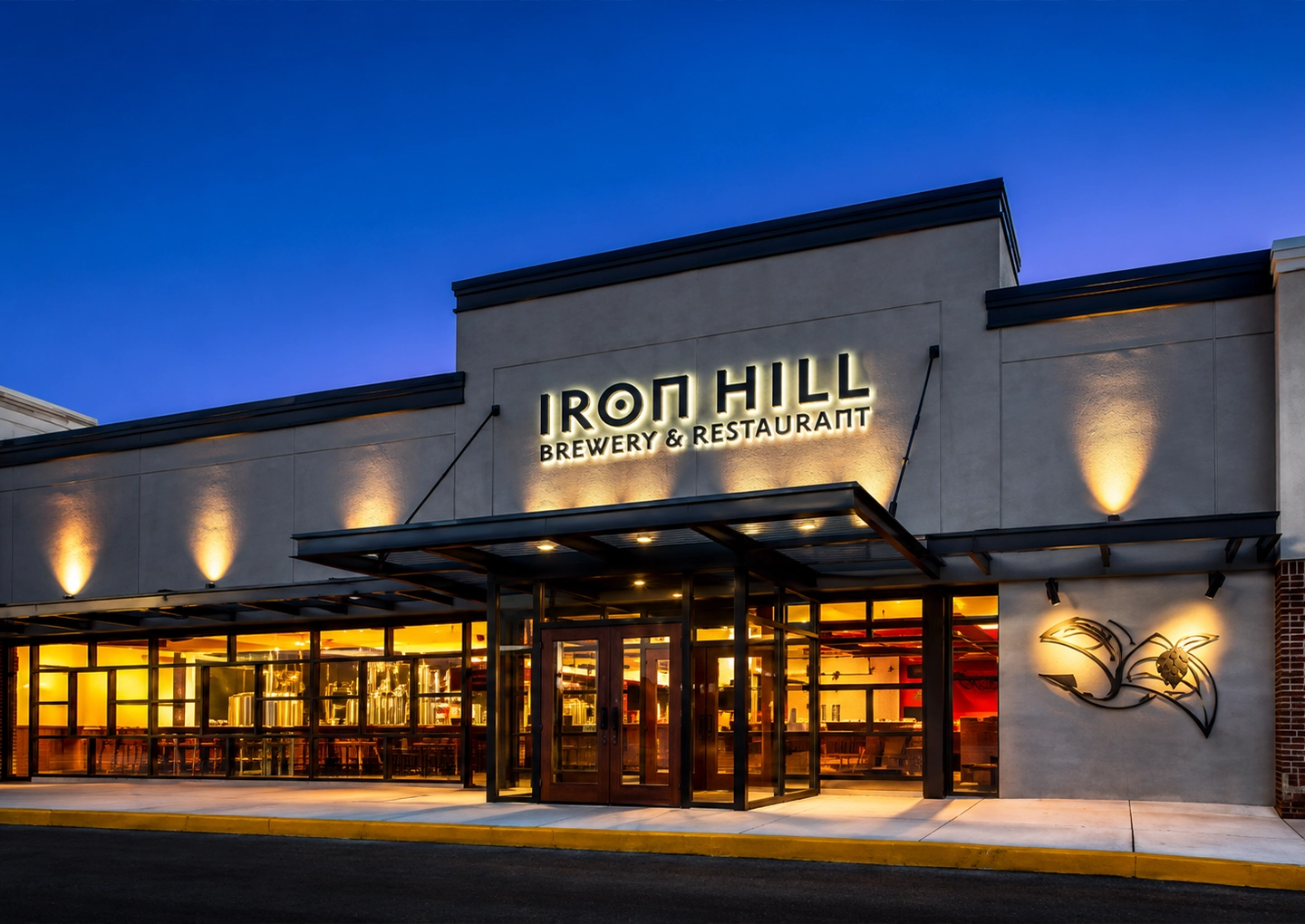 An Iron Hill Brewery storefront glowing at dusk